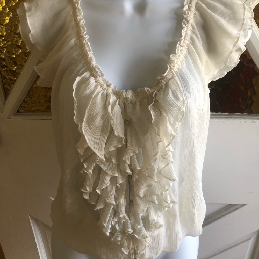 Cream colored ruffled sleeveless blouse